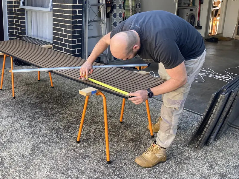Lina measuring up a timber slat panel on trestles before an installation