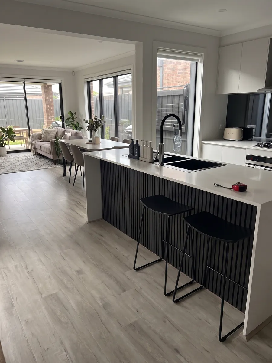 Kitchen island bench fronted with black fluted timber panelling in a Melbourne home